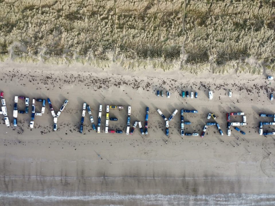 Happy New Year message spelt out by Campervans on Black Rock Sands